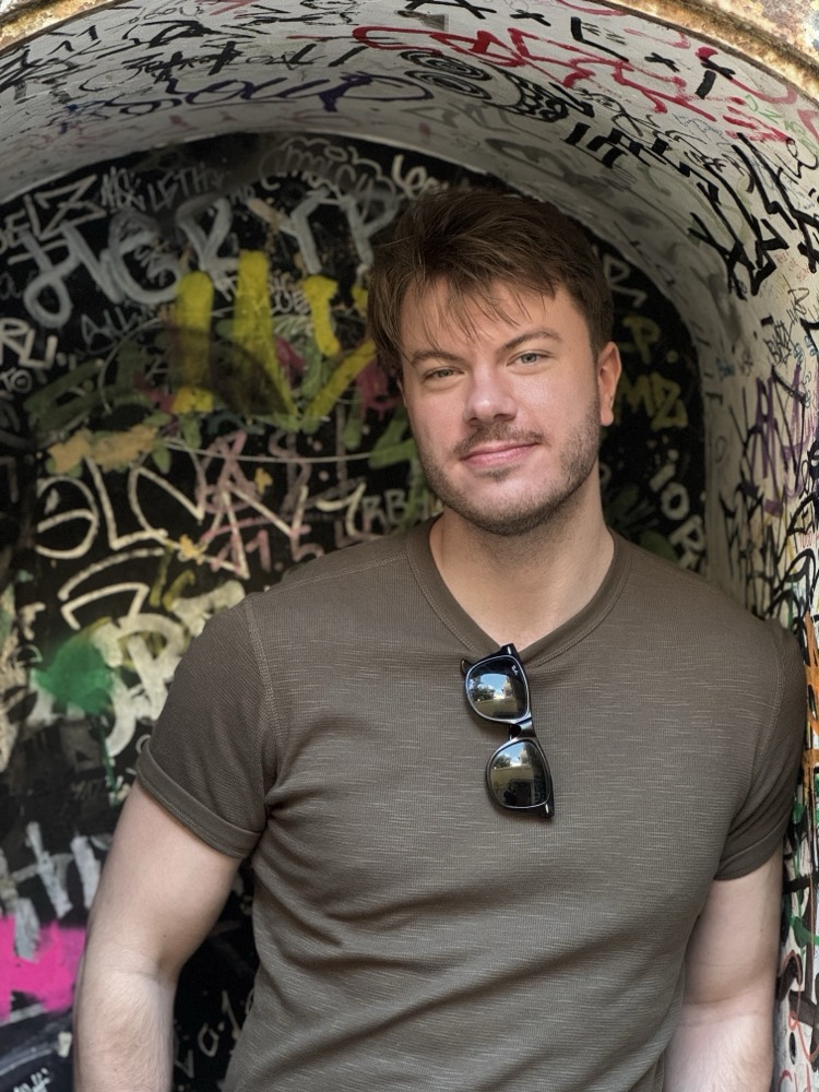Ronny standing in a graffiti-covered underpass